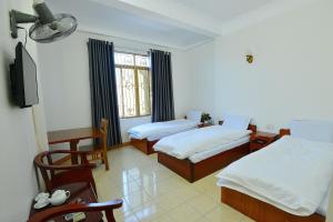 una camera d'albergo con due letti e una tv di Khách Sạn Đông Phương a Lạng Sơn