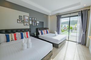 a bedroom with two beds and a balcony at PP Pool Villa Huahin in Hua Hin