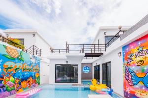 a house with a swimming pool with a painting on the wall at PP Pool Villa Huahin in Hua Hin