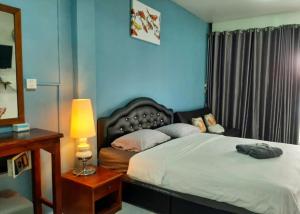 カロンビーチにあるSala Bua Roomのベッドルーム1室(ベッド1台、ランプ付きテーブル付)