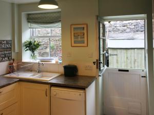 uma cozinha com um lavatório e uma janela em Thorncliffe Cottage em Tideswell