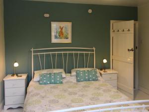 a bedroom with a bed with two night stands and two lamps at Thorncliffe Cottage in Tideswell