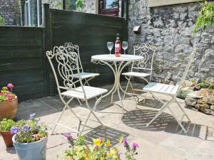 uma mesa com duas cadeiras e uma garrafa de vinho em Thorncliffe Cottage em Tideswell