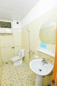 un bagno con lavandino, WC e specchio di Khách Sạn Đông Phương a Lạng Sơn
