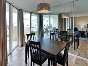 een eetkamer met een houten tafel en stoelen bij Santa Rosa Dunes 1022 in Pensacola Beach