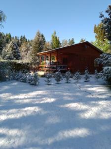 a cabin in the snow with trees in front of it at Cabaña potrerillos La Tabaida in Potrerillos