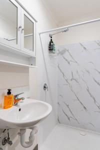 a white bathroom with a sink and a shower at Stay in Blackwood in Blackwood