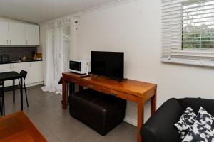 a living room with a desk with a television on it at Stay in Blackwood in Blackwood