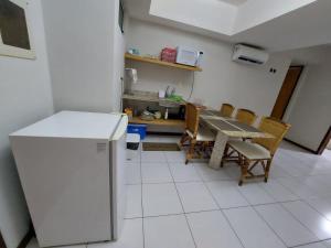een keuken met een tafel en stoelen en een koelkast bij Flat 305 - Flat no Vip Praia Hotel in Natal