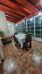 uma sala de jantar com mesa, cadeiras e janelas em Casa Quinta La Gualeya em Gualeguay