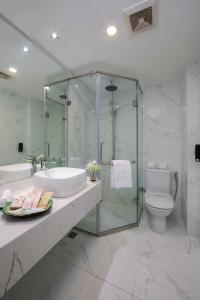 La salle de bains est pourvue d'une douche, d'un lavabo et de toilettes. dans l'établissement Danly Hotel, à Hanoï