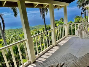 a view from the porch of a house with a hammock at Waterfield Villa in Montego Bay