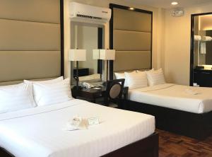 a hotel room with two beds and a mirror at Jinjiang Inn - Boracay Station 1 in Boracay