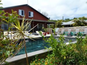 une maison avec une piscine en face d'une maison dans l'établissement Domaine de La Louise, à Saint-Joseph