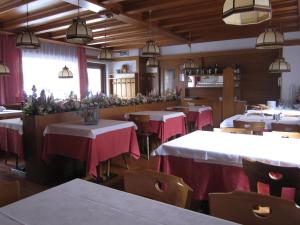 un ristorante con tavoli con tovaglia rossa e bianca di Albergo Valgranda ad Alleghe