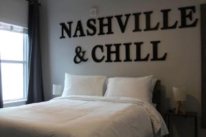 a bedroom with a king sized bed with a nashville and chill sign at Luxury in the Gulch in Nashville
