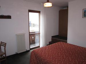 una camera d'albergo con un letto e una finestra di Albergo Valgranda ad Alleghe