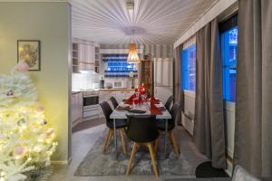 a dining room with a christmas tree and a table and chairs at Kuukkeli Apartments in Saariselka