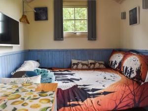 een slaapkamer met een bed, een tafel en een raam bij The Shepherds Hut in Herstmonceux
