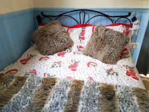 a bed with a santa claus quilt on it at The Shepherds Hut in Herstmonceux