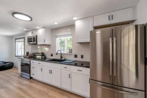 a kitchen with white cabinets and a stainless steel refrigerator at Renovated 4br w/game room to entertain Near DT in Lakewood