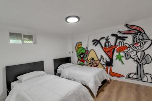 ein Schlafzimmer mit 2 Betten und einem Wandgemälde in der Unterkunft Renovated 4br w/game room to entertain Near DT in Lakewood