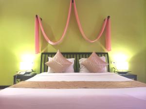 a bedroom with a large bed with pink strings above it at Sudala Beach Resort in Khao Lak
