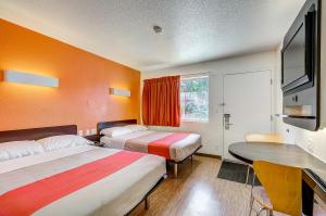 桑顿Motel 6 Thornton, CO的有两张床和一张桌子的酒店房间 更多28张照片