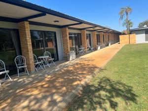 a row of chairs and tables on a building at Jumbuck Motor Inn - POOL - PET FRIENDLY SECTION - KING BEDS in Longreach