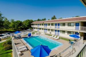 桑顿Motel 6 Thornton, CO的享有酒店泳池的顶部景色,配有蓝色遮阳伞
