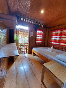 Zimmer mit 2 Betten und 2 Bänken in der Unterkunft Jake and Zyra Place in San Vicente