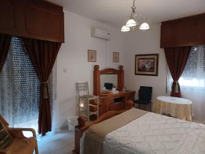 Shared Top 1st floor villa في ليماسول: غرفة نوم بسرير ومكتب وستائر