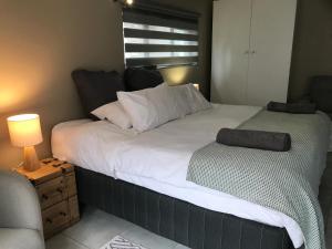 ヨハネスブルグにあるAluve Guesthouseのベッドルーム1室(大型ベッド1台、枕付)