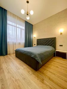 a bedroom with a bed and a large window at 2х комнатная квартира ЖК Арман in Kokshetau