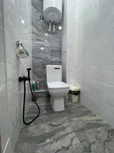 a bathroom with a white toilet and a shower at 2х комнатная квартира ЖК Арман in Kokshetau +6 photos