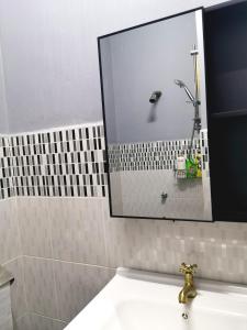ein Bad mit einem Waschbecken, einem Spiegel und einer Dusche in der Unterkunft D2Pie Homestay in Subang Jaya