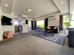 a living room with a couch and a tv at Lakefront Gem, Absolute Waterfront in Queenstown