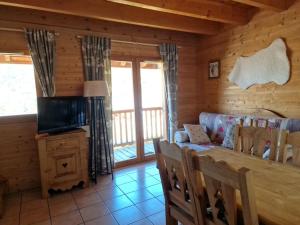 un soggiorno con divano e TV in una cabina di Saint François Longchamps Loc à la Montagne avec piscine été hiver vg23 a Saint-François-Longchamp