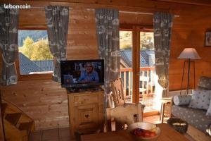 un soggiorno con TV in una baita di tronchi di Saint François Longchamps Loc à la Montagne avec piscine été hiver vg23 a Saint-François-Longchamp Altre 7 foto