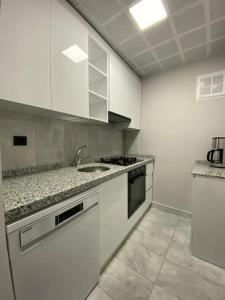 una cucina bianca con lavandino e piano di lavoro di Whole Apartment at The Heart of Sisli Nisantasi K a Istanbul