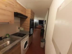 a small kitchen with a sink and a washing machine at Appartement de vacances - Splendide vue sur mer, Parking privé in Le Barcarès