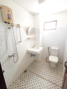 uma casa de banho com um WC, um lavatório e um chuveiro em Manilath guesthouse em Ban Houayxay