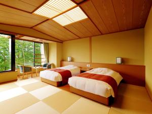 two beds in a bedroom with a skylight at Jodogahama Park Hotel in Miyako