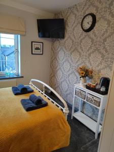 a bedroom with a bed and a clock on the wall at Rooms by the River at Glan Aber in Corwen