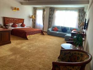 Habitación de hotel con cama y sofá en Asia & Africa Hôtel en Antananarivo