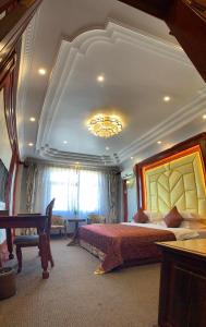 a large bedroom with a bed and a chandelier at Asia & Africa Hôtel in Antananarivo