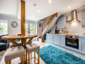 a kitchen with blue cabinets and a wooden table at The Dog And Trout in Findon