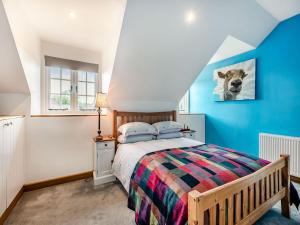 a bedroom with a bed and a blue wall at The Dog And Trout in Findon