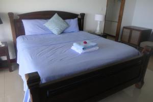 ein Bett mit zwei Handtüchern und einer roten Rose drauf in der Unterkunft Tropical Garden Self Catering in Victoria