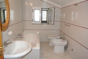 La salle de bains blanche est pourvue d'un lavabo et de toilettes. dans l'établissement Dimora1 MGM, à Marconia